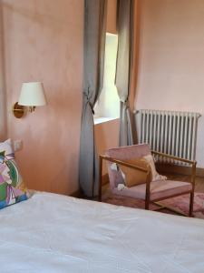 - une chambre avec un lit, une chaise et une fenêtre dans l'établissement Jardin Meurin, à Tabanac