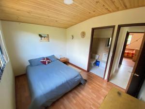 a bedroom with a blue bed and a wooden ceiling at Suanoga - Finca Turística in Pesca