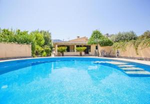 een groot zwembad met blauw water bij Finca Sa Sort Llarga in Pollença