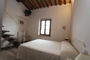 a bedroom with a white bed and a window at Agriturismo San Martino in Ponsacco