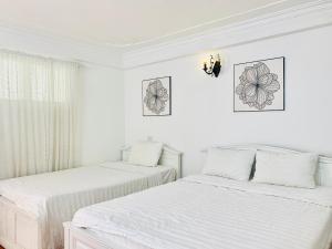 - 2 lits dans une chambre aux murs blancs dans l'établissement Hotel Mini, à Phú Thọ