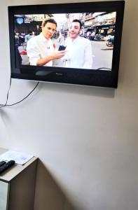 TV de pantalla plana colgada en la pared en Хостел "На Янгеля" с парковкой WIFI, en Vínnytsia
