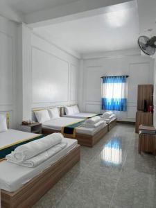 a bedroom with three beds in a room at NHÀ NGHỈ LÊ ĐƯỢC 2 in Ha Tien