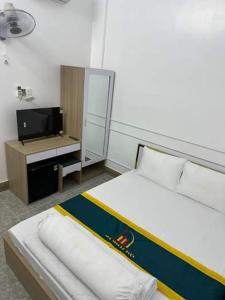 a hotel room with a bed and a television at NHÀ NGHỈ LÊ ĐƯỢC 2 in Ha Tien