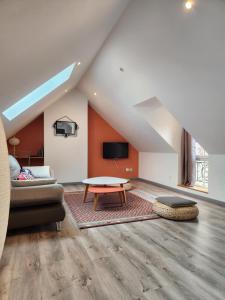 ein Wohnzimmer mit einem Sofa und einem Tisch in der Unterkunft Appartement calme Le clos de Renée in Hautvillers