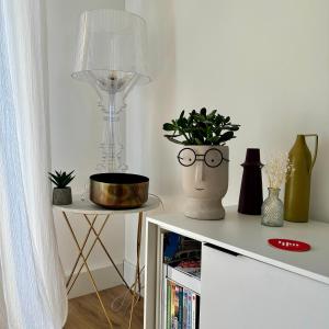 a table with glasses and a vase with a plant on it at Nouveau ! T2 neuf avec vue imprenable mer in Ajaccio