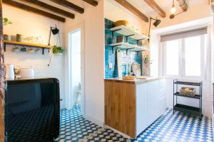 a kitchen with a counter and a tv in a room at Studio Blue LX- 1 de Maio in Lisbon +26 photos