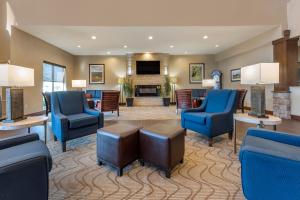 a hotel lobby with blue chairs and a fireplace at Comfort Suites Bridgeport - Clarksburg in Bridgeport