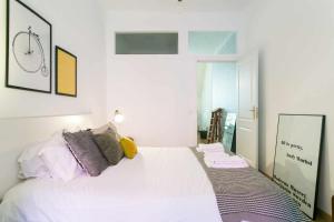 a bedroom with a white bed with pillows and a mirror at St Amaro- Chic Terrace Studio Lisbon Congress in Lisbon