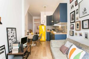 a living room with a couch and a kitchen at St Amaro- Chic Terrace Studio Lisbon Congress in Lisbon