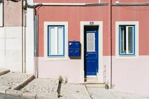 a building with a blue door on the side of it at St Amaro- Chic Terrace Studio Lisbon Congress in Lisbon +18 photos