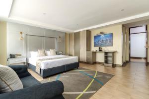 Habitación de hotel con cama y sofá en Dallas Premiere Hotel en Kisii