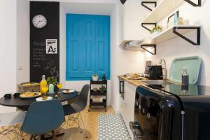 a kitchen with a table and a blue door at Blue Centro da Cidade Ar Condicionado in Lisbon