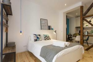a bedroom with a white bed and a table at Blue Centro da Cidade Ar Condicionado in Lisbon