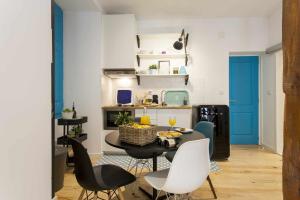 a room with a table and chairs and a kitchen at Blue Centro da Cidade Ar Condicionado in Lisbon