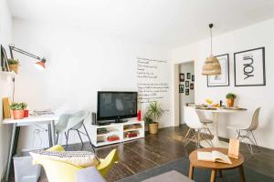uma sala de estar com uma televisão e uma mesa em Confortável Apartamento Centro da Cidade Univ em Lisboa