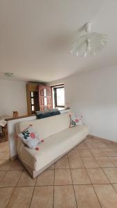 un sofá blanco en una sala de estar con techo en Apartma Emilio, en Breginj