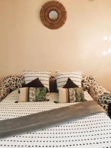 a bed with black and white polka dot sheets and pillows at STUDIO DE L'HORLOGE in Dinan