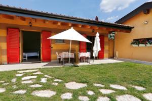 a patio with a table and an umbrella on a house at Agriturismo Terra e Lago d'Iseo Franciacorta in Paratico