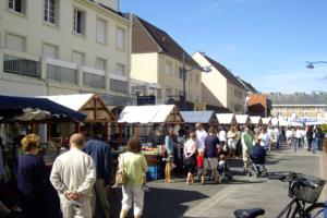 a group of people walking around an outdoor market at Appartement A confortable et lumineux in Neufchâtel-Hardelot