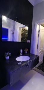 a black bathroom with a sink and a mirror at فيلا بشاطي رملي خاص ومسبح عالبحر - درة العروس شاطي البردايس in Durat  Alarous