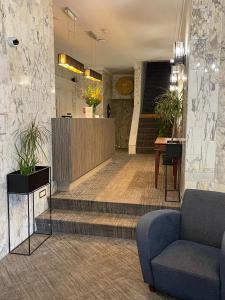 a lobby with stairs and a blue couch in a room at City Hotel Tilburg in Tilburg