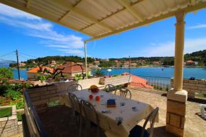 a table and chairs on a patio with a view of the water at Apartments Radojkovic in Lumbarda