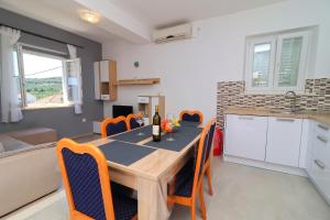 a kitchen and dining room with a table and chairs at Apartments Radojkovic in Lumbarda