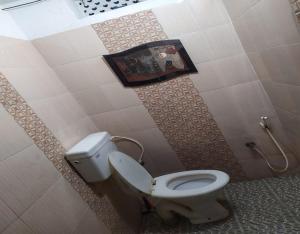 y baño con aseo y ducha. en Laxmi Sagar Homestay by StayApart, en Puri