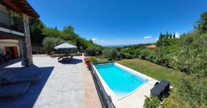 een zwembad in een tuin met een tafel en stoelen bij Casa Quarole Garda-Meer in Cavaion Veronese