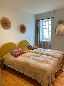 普萊納瓦昂德雷的住宿－Maison Ker Hélios，一间卧室配有一张带两把椅子的床和一扇窗户