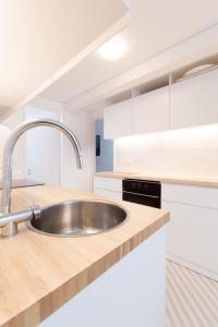 eine Küche mit einem Waschbecken und weißen Schränken in der Unterkunft Apartamento na Vila in Fão