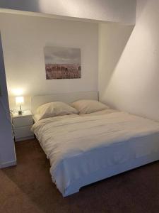 a bedroom with a white bed and a lamp on a table at Exklusive Wohnung in der schönen Stadt Bremen in Bremen