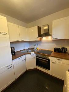 uma cozinha com armários brancos e um forno com placa de fogão em Exklusive Wohnung in der schönen Stadt Bremen em Bremen