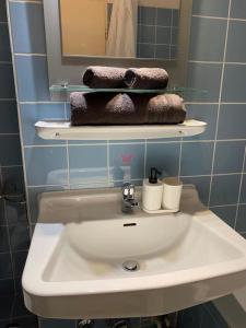 ein Badezimmer mit einem Waschbecken, einem Spiegel und Handtüchern in der Unterkunft Exklusive Wohnung in der schönen Stadt Bremen in Bremen