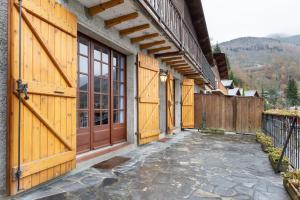 a pair of wooden doors on a building with a patio at Chalet Les Noisetiers in Saint-Lary-Soulan