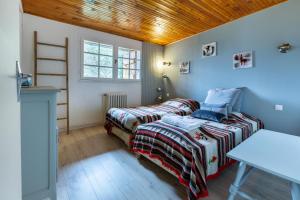- une chambre avec deux lits et un plafond en bois dans l'établissement Chalet Les Noisetiers, à Saint-Lary-Soulan