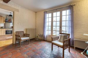 a living room with two chairs and a large window at Chalet Les Noisetiers in Saint-Lary-Soulan