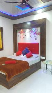 een slaapkamer met een groot bed met een rood hoofdeinde bij Krishna Niwas in Mahabaleshwar