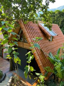 una casa con techo rojo y terraza en Pousada Tekoá Indiana, en Cachoeiras de Macacu