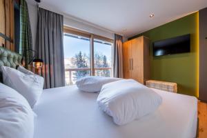 1 dormitorio con 2 almohadas blancas en una cama en Höflehner Premium Eco Lodge en Haus im Ennstal