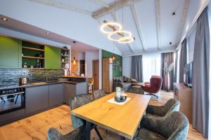 cocina y comedor con mesa de madera y sillas en Höflehner Premium Eco Lodge en Haus im Ennstal