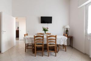 een eetkamer met een tafel met stoelen en een televisie bij Casa Gina - Welcome in Italy! in Scandicci