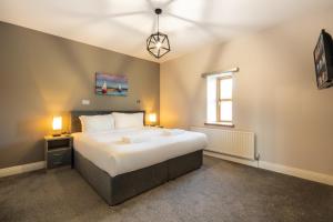 a bedroom with a large white bed and a window at Escape Ordinary at Castle Hume in Enniskillen