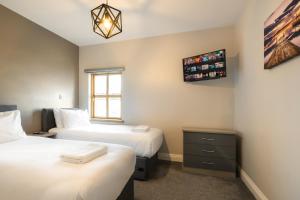 a bedroom with two beds and a window at Escape Ordinary at Castle Hume in Enniskillen