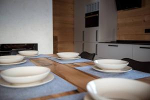 une table en bois avec des bols et des assiettes blanches dessus dans l'établissement Montana górska chata, à Brenna 15 autres photos
