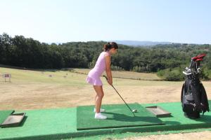 Eine Frau, die Golf auf einem Putting Green spielt. in der Unterkunft Agriturismo San Martino in Ponsacco
