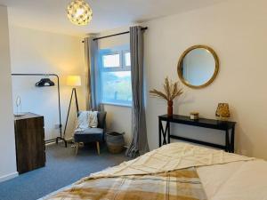 Ystradowen的住宿－2Bed Annexe nr Vale Resort, Golf & Spa，一间卧室配有一张床、镜子和椅子