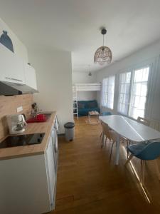 uma cozinha e sala de jantar com mesa e cadeiras em ATLANTIS em Saint-Nazaire