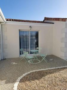 un patio con 2 sillas y una mesa frente a un edificio en Angoulême Nord location Chambre indépendante en Champniers